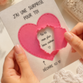 Carte surprise faite à la main avec des éléments décoratifs et un message d'amour.