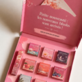Nouvelles teintes de blush Benefit sur un fond coloré.
