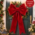 Nœud de Noël élégant accroché à une porte en bois, décoré pour les fêtes.